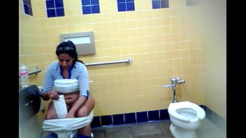 Señora madura se lava la concha con agua en baño público