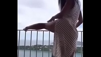 Latina bailando sexy se desnuda en el balcón